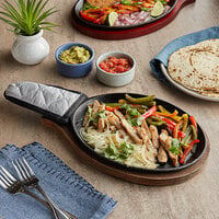 Choice 9 1/4 inch x 7 inch Oval Pre-Seasoned Cast Iron Fajita Skillet with Oak Finish Wood Underliner and Grey Silicone Handle Cover