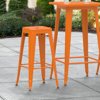 Lancaster Table & Seating Alloy Series Orange Stackable Metal Indoor / Outdoor Industrial Barstool with Drain Hole Seat