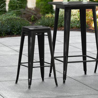 Lancaster Table & Seating Alloy Series Distressed Black Stackable Metal Indoor / Outdoor Industrial Barstool with Drain Hole Seat