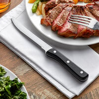 Choice 4 3/4 inch Jumbo Stainless Steel Steak Knife with Black Bakelite Riveted Handle - 12/Case