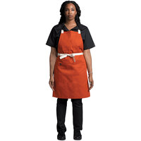 Uncommon Threads 3127 Orange Customizable Poly-Cotton Avalanche Bib Apron with Natural Webbing and 3 Pockets - 34 inchL x 23 inchW