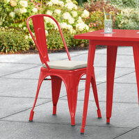 Lancaster Table & Seating Alloy Series Red Stackable Metal Indoor / Outdoor Industrial Cafe Chair with Vertical Slat Back and Tan Fabric Magnetic Cushion
