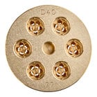 A circular gold metal object with holes in it.
