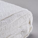 A folded white Oxford 100% cotton thermal blanket.