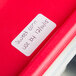 A red surface with a white National Checking Company blank dissolvable label sticker with black writing.