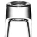 An Arcoroc tall shot glass with a black rim filled with a clear liquid.