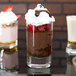 A group of Arcoroc shot glasses filled with chocolate desserts and raspberries.