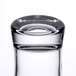 A close-up of a clear Arcoroc shot glass with a white background.