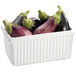A Tablecraft white rectangular server with ridges holding purple and green eggplants.