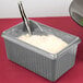 A Tablecraft natural rectangle server with white rice and a spoon.
