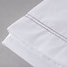 A white Oxford T200 Superblend XL flat sheet with brown stitching on it.