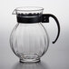 A clear plastic pitcher with a black handle.
