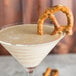 A Chef & Sommelier martini glass filled with a martini and a pretzel.