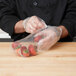 A person in a chef's uniform using LK Packaging plastic bags to hold strawberries.