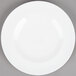 An Arcoroc white porcelain salad plate with a circular rim.