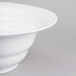 A close-up of a Tablecraft white cast aluminum wide rim salad bowl.