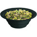 A Tablecraft black cast aluminum bowl with green speckles filled with salad.