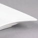 A CAC Miami bone white rectangular porcelain platter with curved edges on a gray surface.