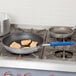 A Vollrath Wear-Ever aluminum non-stick fry pan with meat cooking in it.