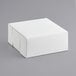 A 9" x 9" x 4" white bakery box on a gray surface.