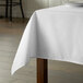 A table with a white Intedge rectangular tablecloth.