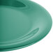 A close-up of a green Carlisle Sierrus melamine salad plate with a wide rim.