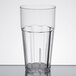 A close-up of a clear Thunder Group polycarbonate tumbler with a black rim.