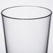 A clear plastic mixing glass with a black rim.