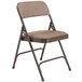 A brown National Public Seating metal folding chair with a russet walnut fabric padded seat.