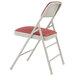 A National Public Seating gray metal folding chair with a red cushion.
