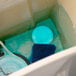 A blue and white package of 2000 Flushes Blue Plus Bleach Automatic Toilet Bowl Cleaner on a counter.