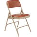 A National Public Seating beige metal folding chair with a honey brown vinyl padded seat.