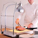 An Alto-Shaam carving station with a chef slicing meat on a cutting board.