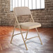 National Public Seating 2201 Beige Metal Folding Chair with 1 1/4" Cafe Beige Fabric Padded Seat Main Thumbnail 1