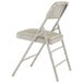 A gray metal folding chair with a warm gray vinyl padded seat.