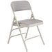 A grey National Public Seating metal folding chair with a grey padded seat.