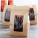 A group of brown Choice brown kraft paper bags with coffee beans in them.