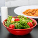 A red GET Melamine bowl filled with salad and pasta.