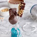 Chocolate covered marshmallows on Paper Lollipop Sticks in a blue glass vase.