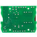 A green circuit board with silver metal and many small holes.