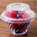A plastic container with a clear plastic lid filled with red and blue candies.