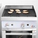 A Cooking Performance Group gas countertop charbroiler with chicken cooking on it.