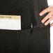 A person wearing a Chef Revival black apron with a pen in the pocket.