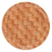 A Cambro round fiberglass tray with a light basketweave pattern on a wooden surface.