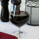 A Spiegelau Vino Grande cognac glass filled with red wine on a table.