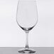 A clear Spiegelau Vino Grande Bordeaux wine glass on a table with a white tablecloth.