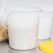A white Rubbermaid food storage container with a yellow lid.