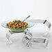 An American Metalcraft stainless steel curl riser set holding a bowl of pasta with vegetables.