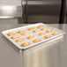 A Baker's Mark parchment paper sheet on a baking tray with pastries.