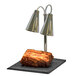 A Hanson Heat Lamps stainless steel carving station with two lamps heating a large piece of meat.